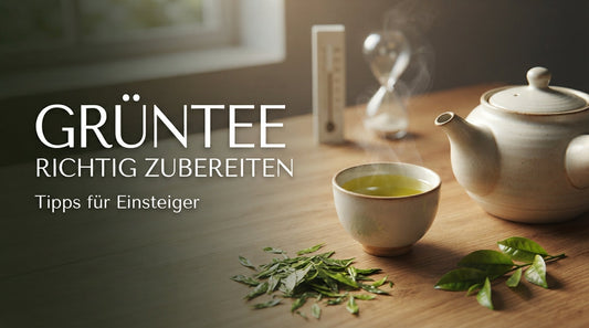 „Blog-Thumbnail zum Fachartikel ‚Grüntee richtig zubereiten‘ mit einer eleganten Keramik-Teekanne, Teetasse und frischen Teeblättern auf einem Holztisch.“