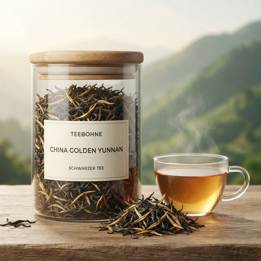 Hochwertiges E-Commerce-Produktfoto von TeeBohne: Eine transparente Glasteedose mit Holzdeckel enthält China Golden Yunnan Schwarztee mit deutlich sichtbaren goldenen Blattspitzen. Neben der Dose liegen lose Teeblätter auf einer Holzoberfläche. Rechts daneben steht eine transparente Teetasse mit einem bernsteinfarbenen Aufguss. Der Hintergrund zeigt subtil eine Berglandschaft in weichem Morgenlicht.